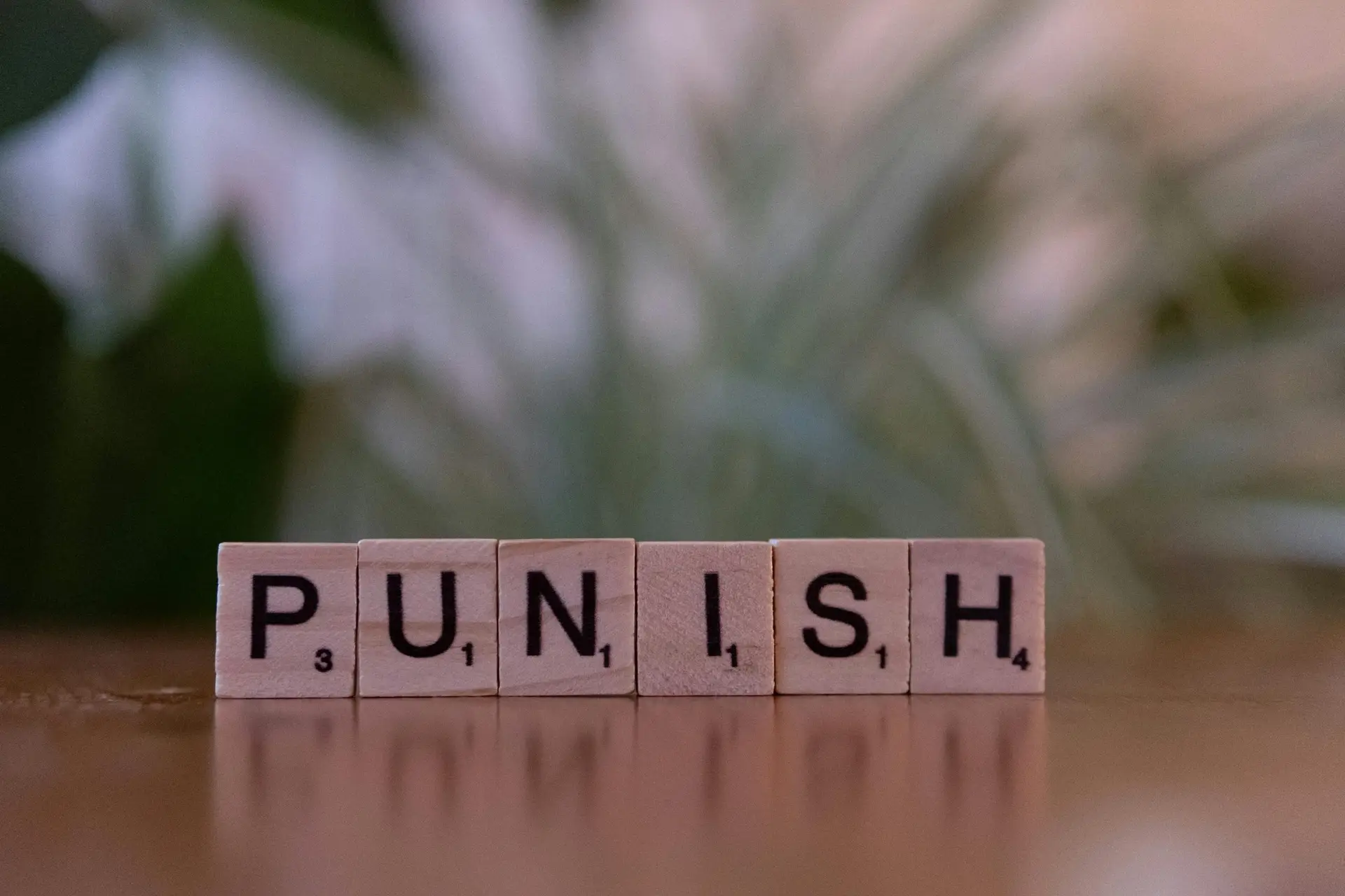 Punish the Limpers Scrabble tiles spelling 'punish' against a blurred natural background.